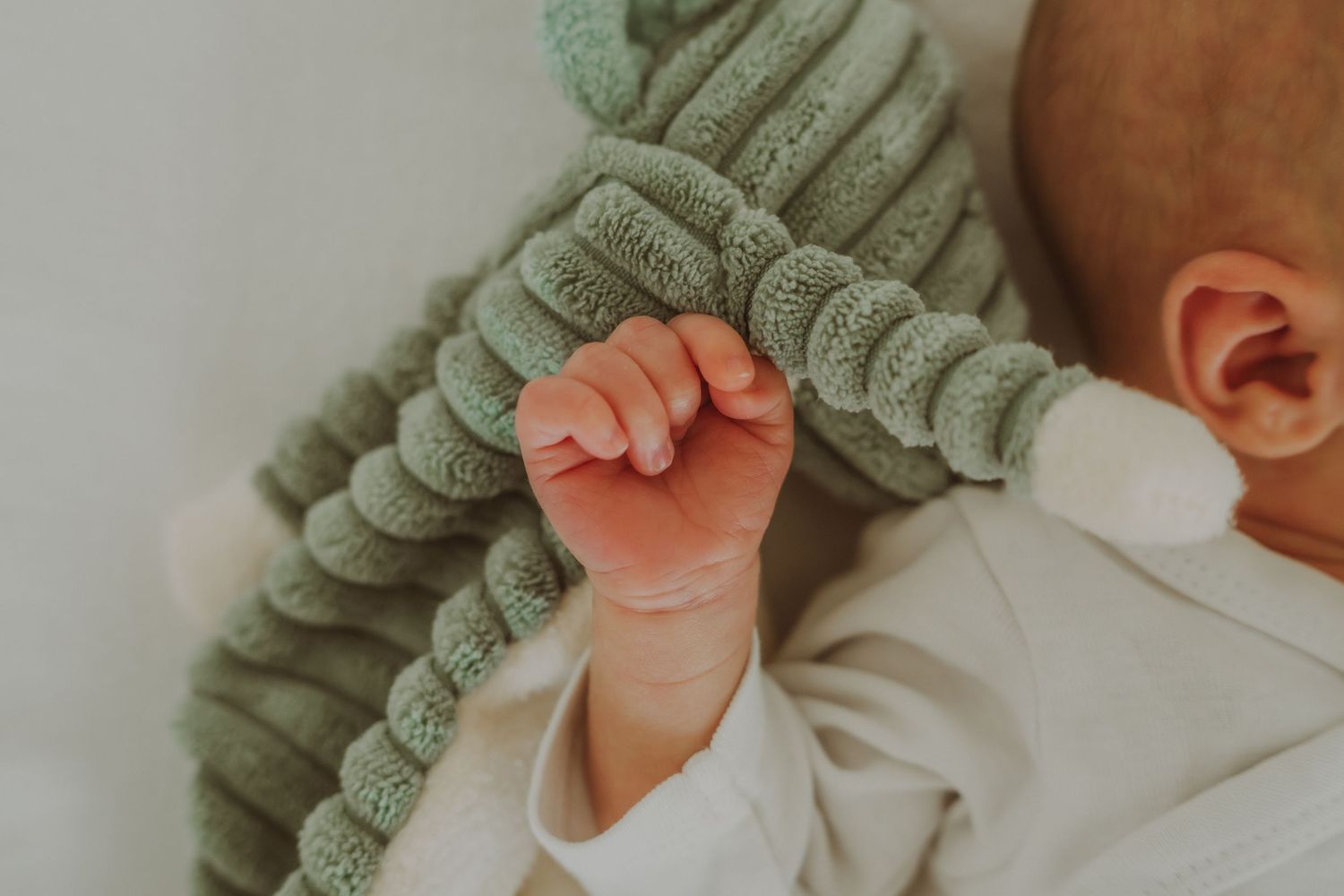 Newborn fotografie — baby in saliegroen truitje