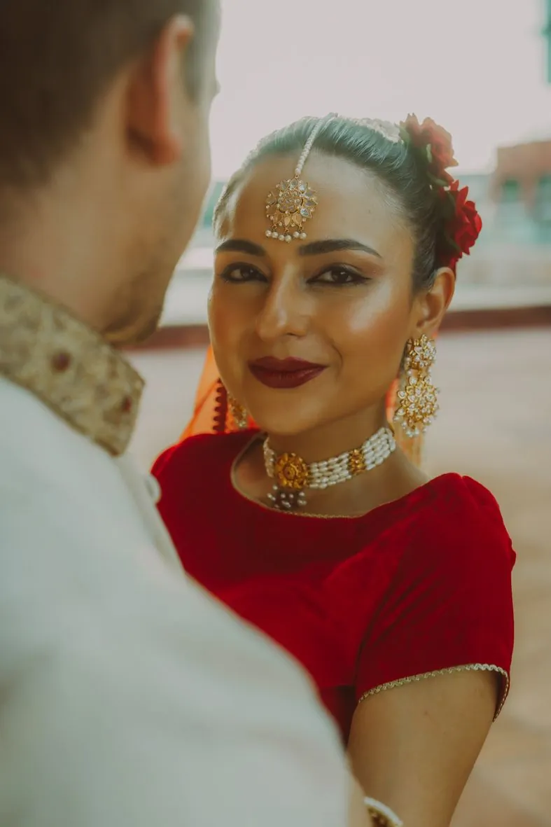 Gros plans de la mariée en tenue de mariage indien rouge avec bijoux ornementaux