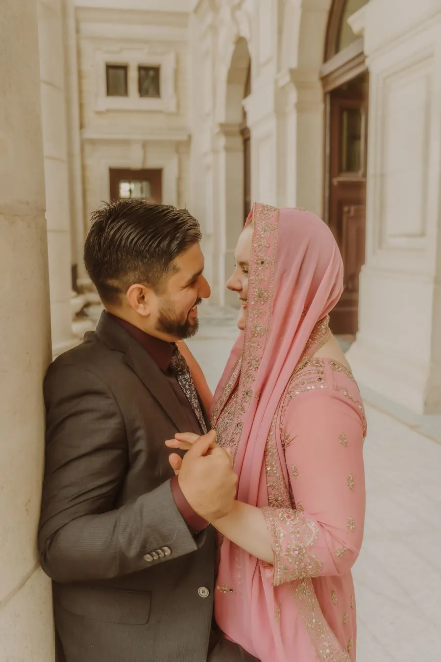 Couple romantique en tenue de fête près de piliers blancs