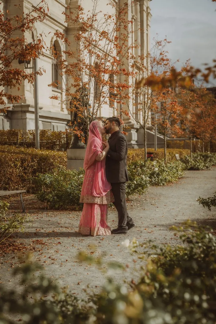 Couple dans un jardin automnal entouré de feuilles orangées