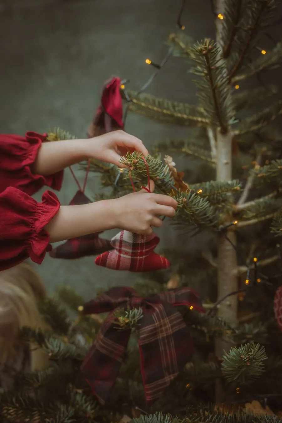 Hands on the tree Hands decorating the Christmas tree