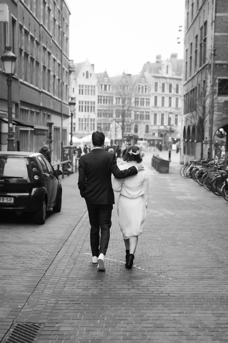Photo en noir et blanc d'un couple marchant sur des pavés dans une ville historique