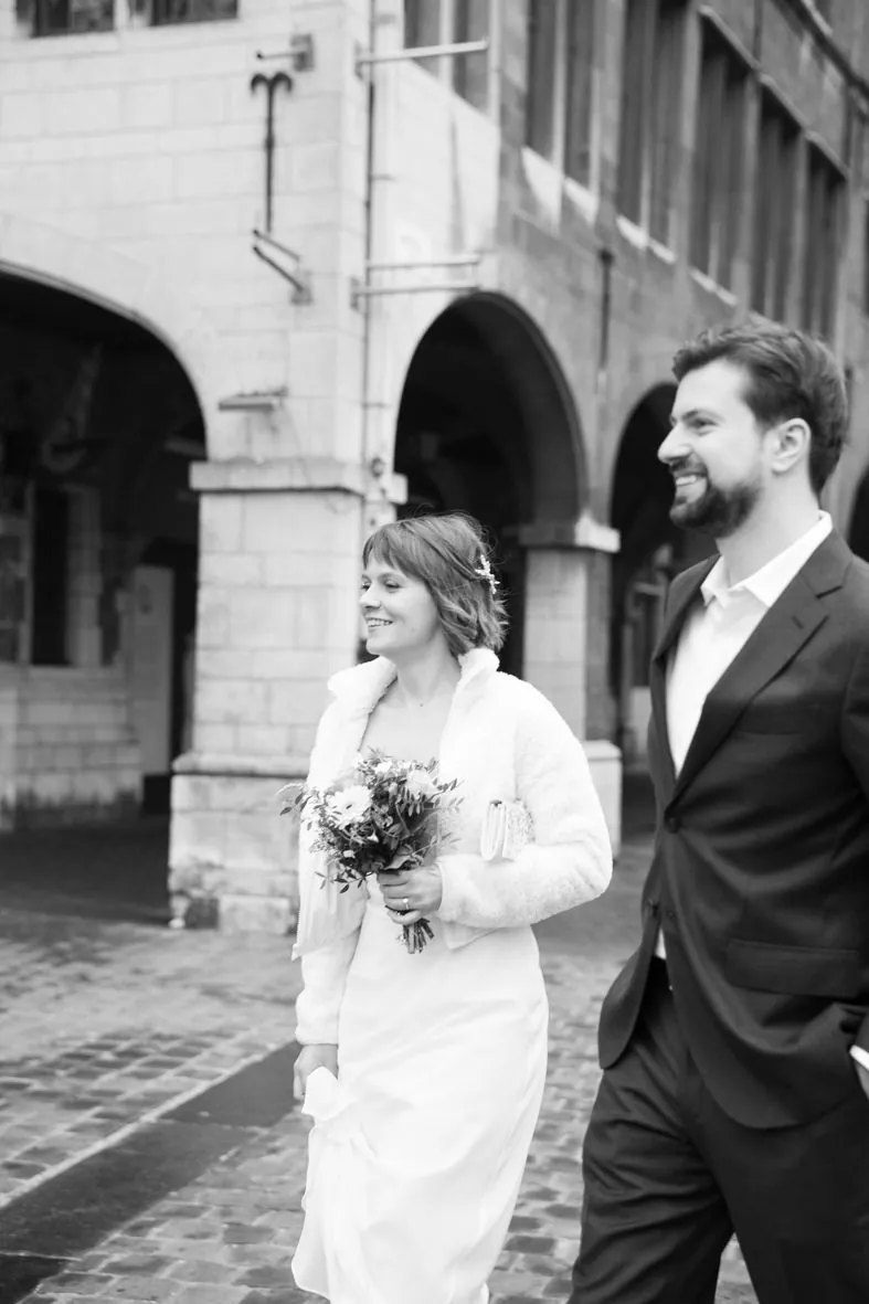 Photo en noir et blanc d'un couple près d'un bâtiment en pierre