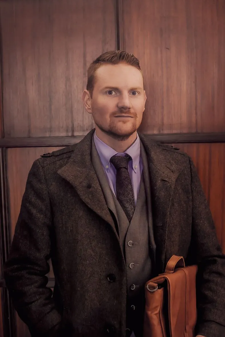 Série de portraits en costume tweed marron et chemise violette devant un mur en bois