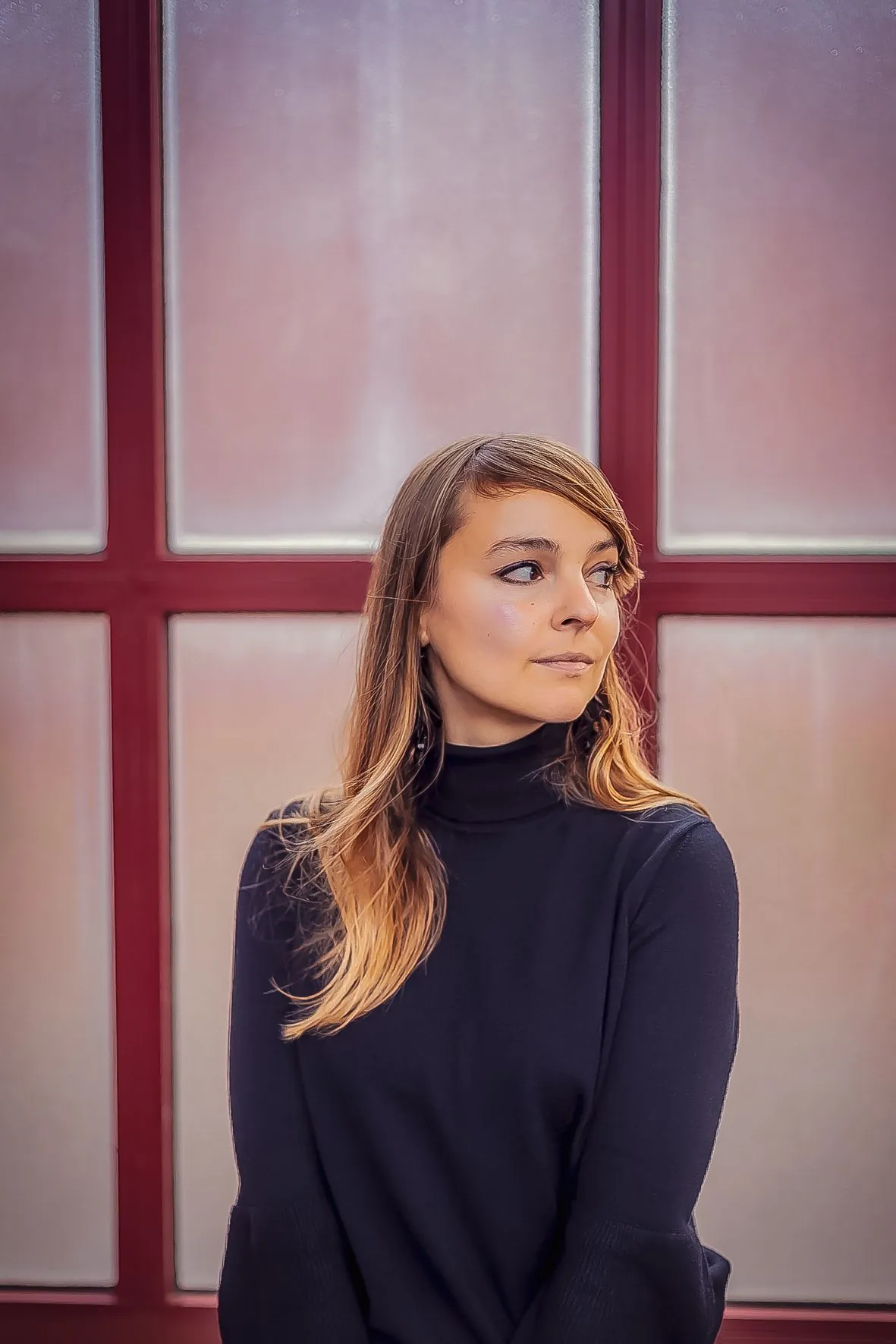 Série de portraits d'une personne en col roulé noir devant fond rose