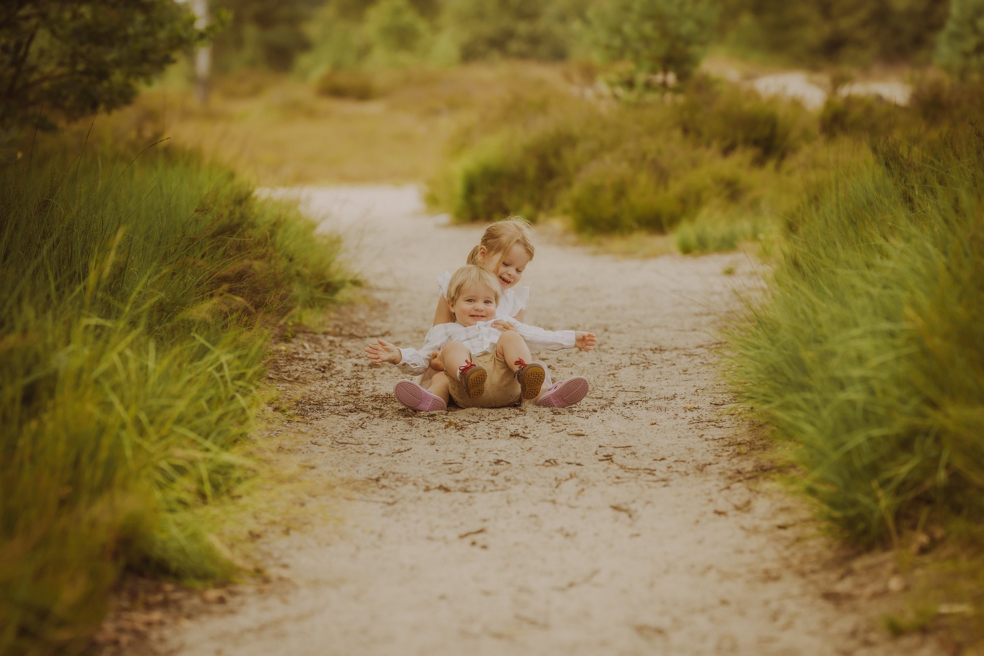 Spelende kinderen op een bospad tijdens een familieshoot